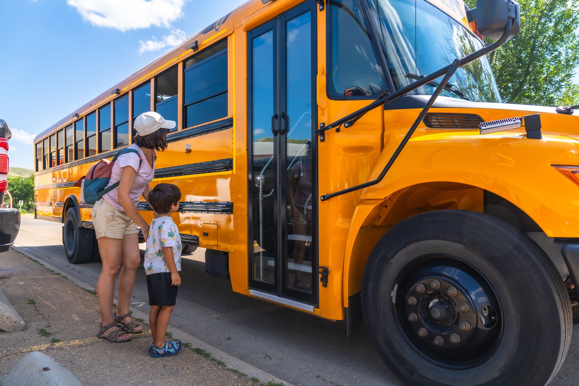 Mother and son waiting for school bus on first day back to school